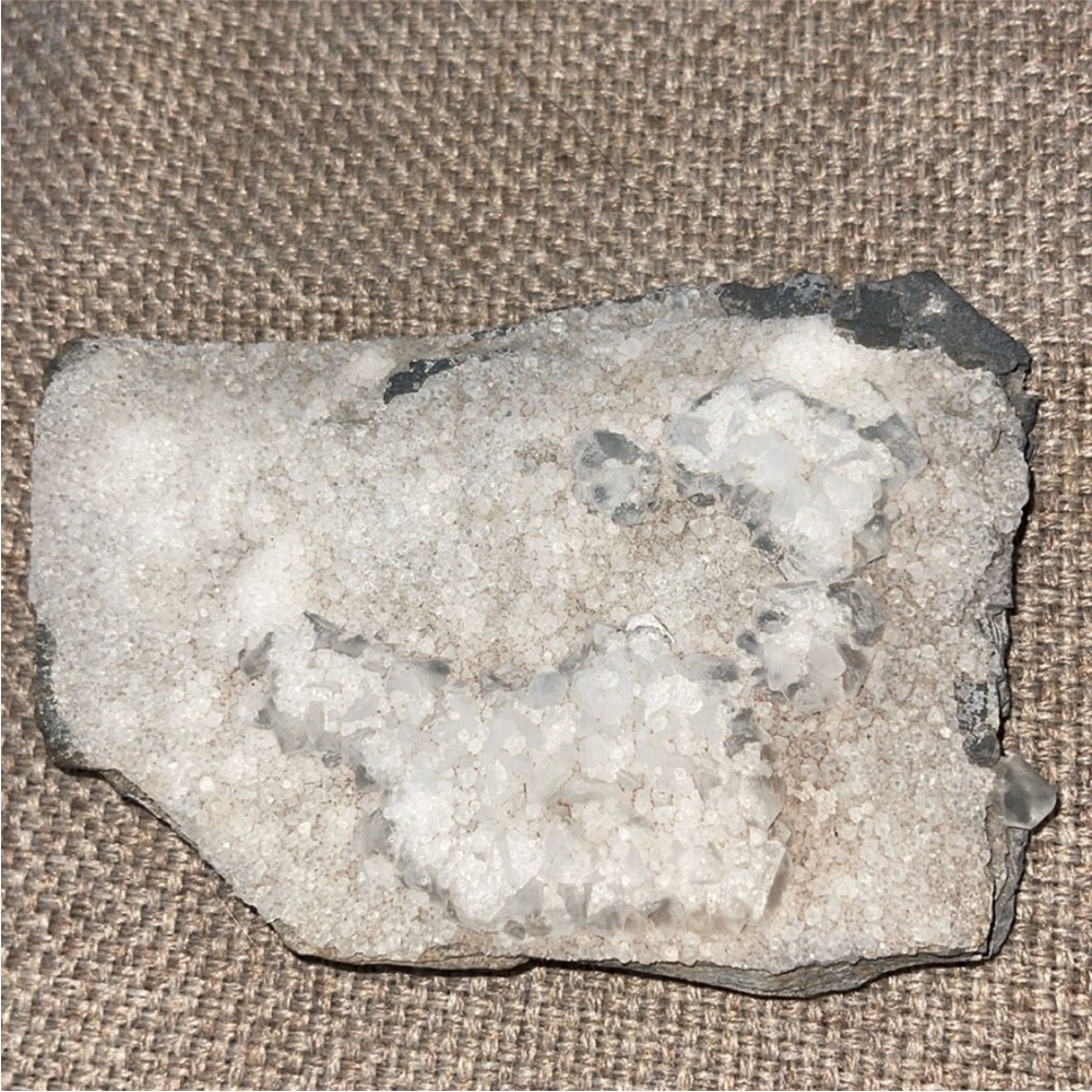 White Crystals on a gray blue slate rock. Approx. 6” by 4”
